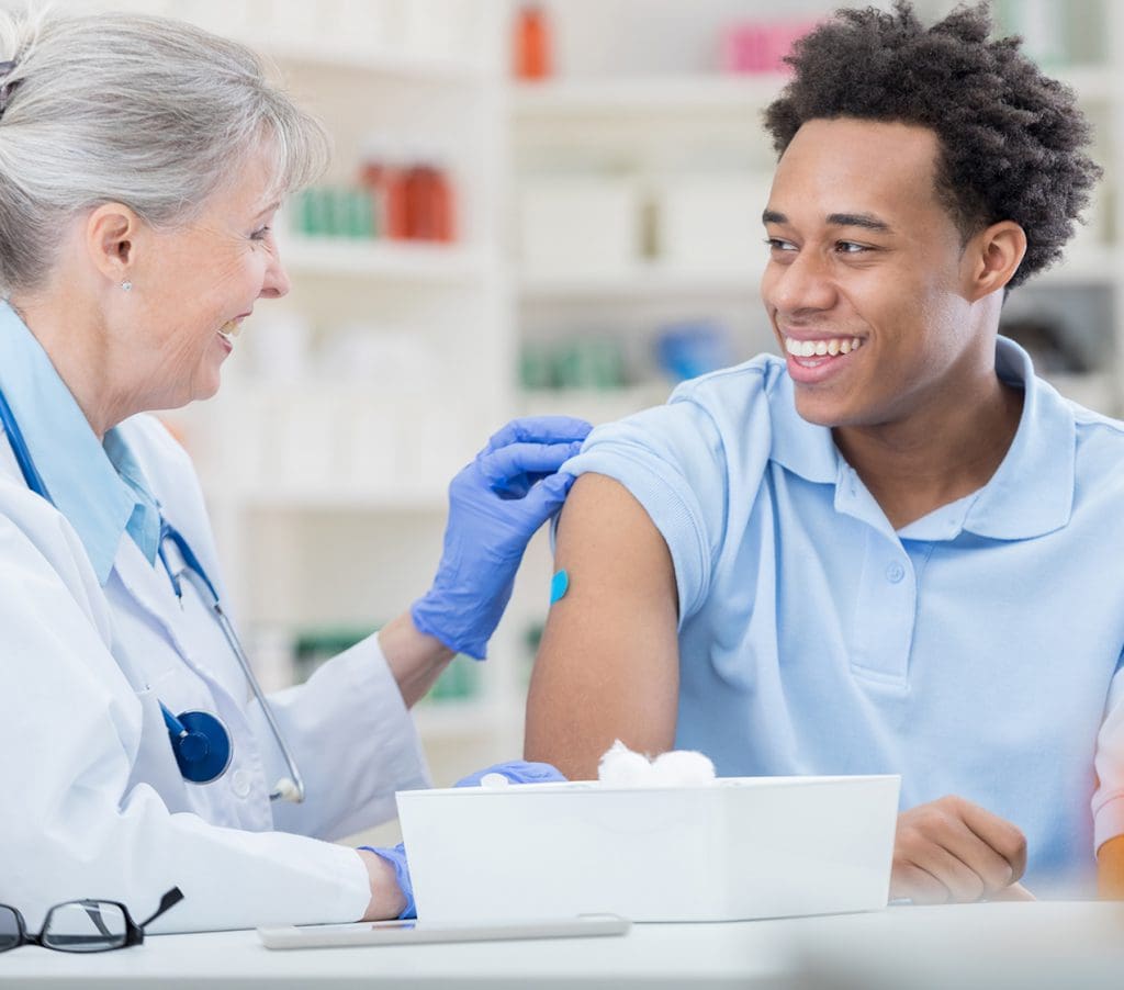 pharmacist sanitizing patient's arm