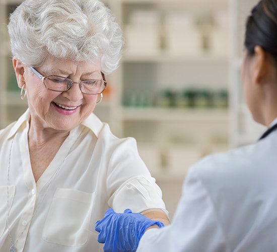 pharmacist applying a bandage to a senior female