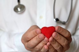 healthcare provider holding a small knitted heart